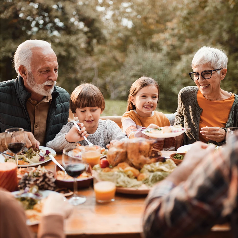 family eating a meal outside at a table family eating a meal outside at a table