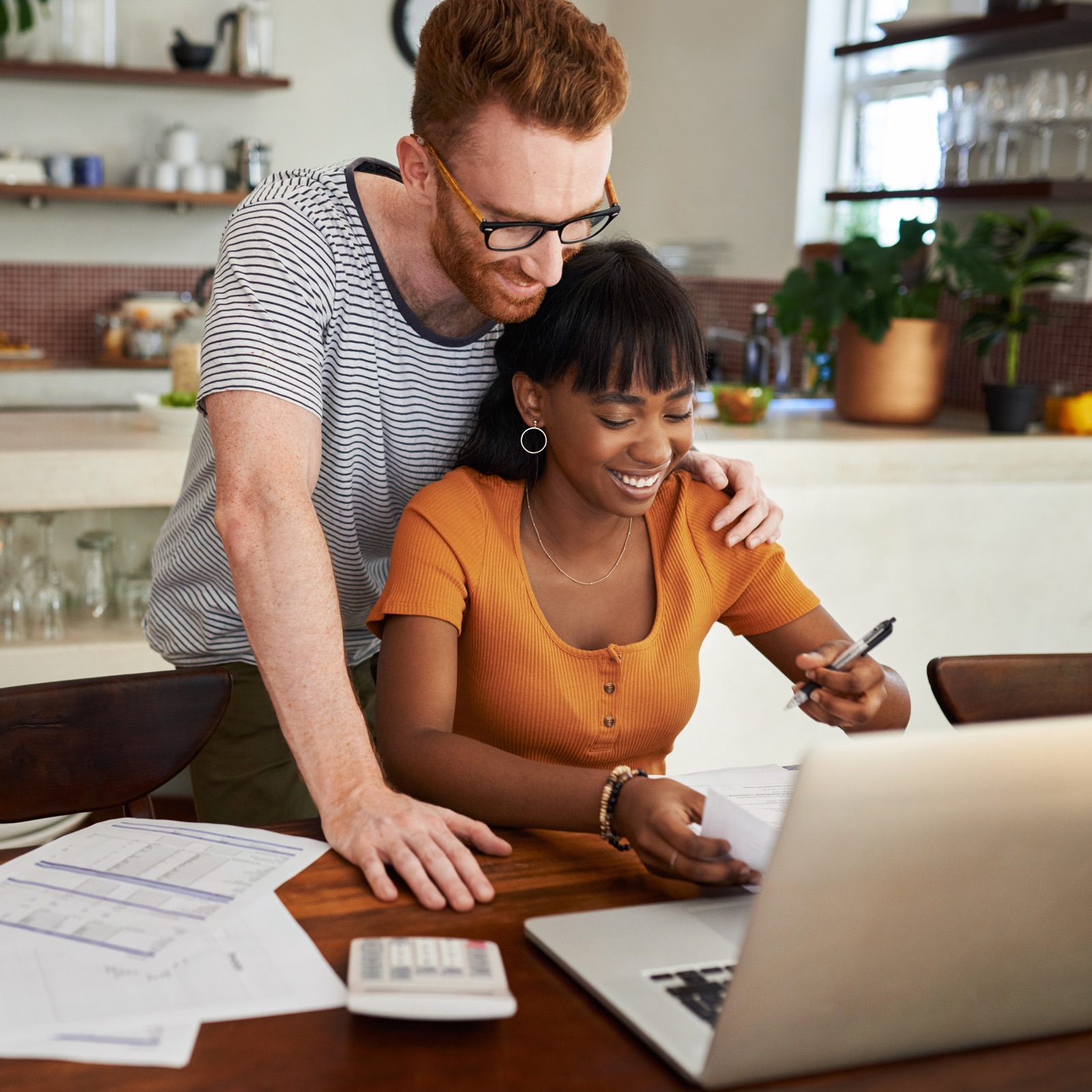 a man and woman looking at a laptop