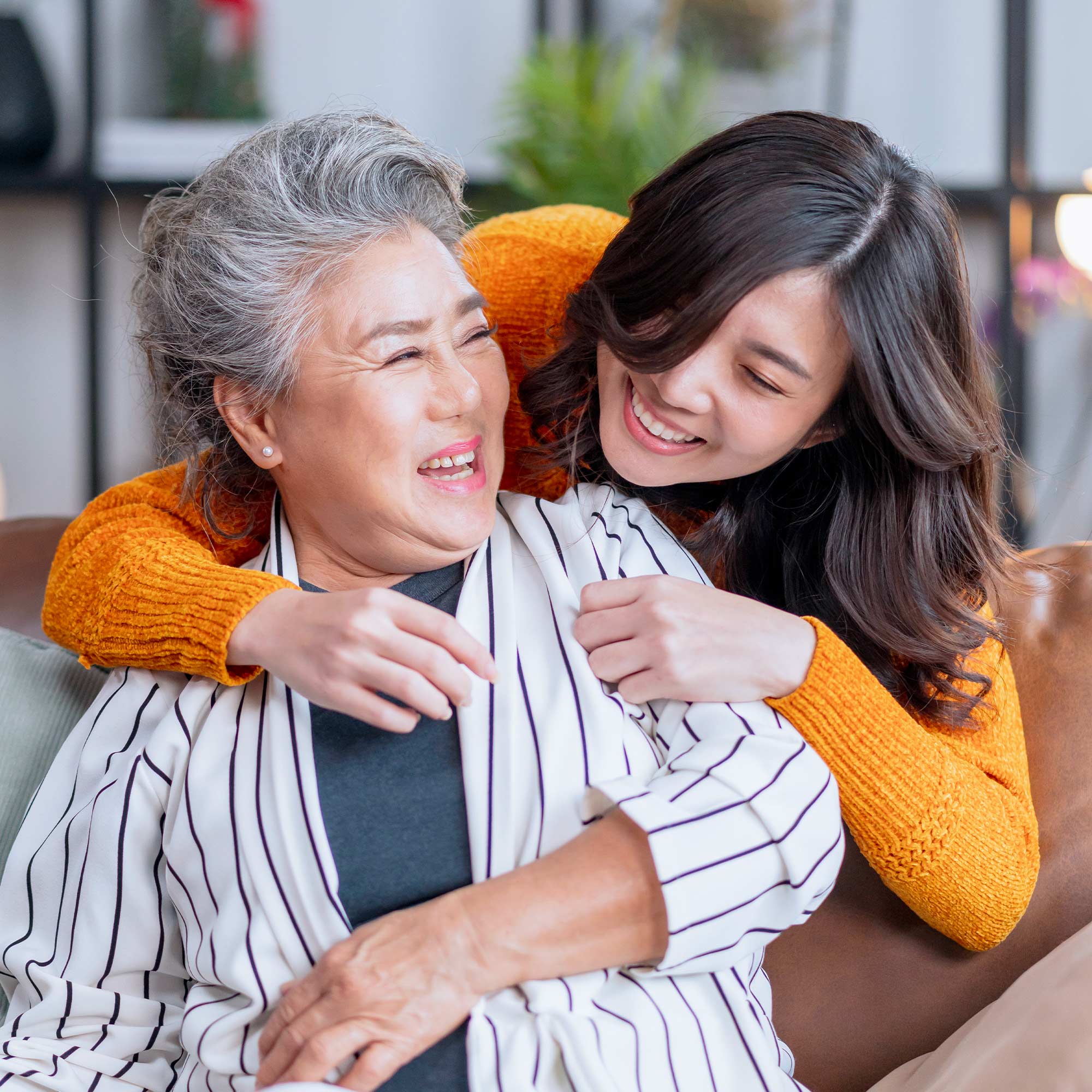 a woman hugging an older woman on a couch