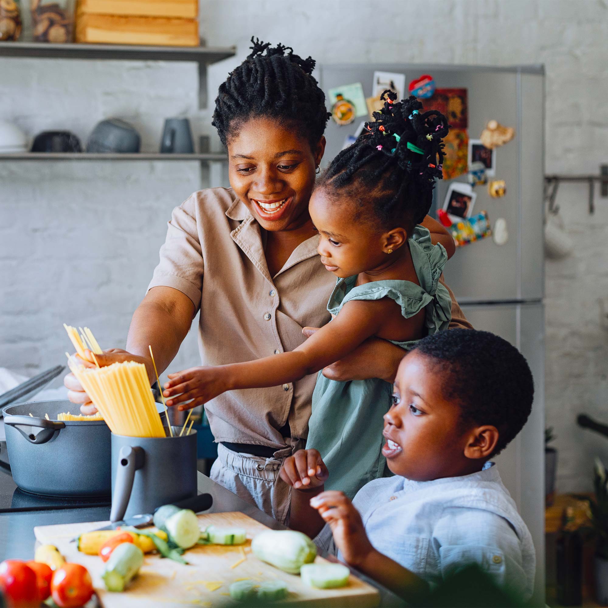 a woman and children cooking in a kitchen