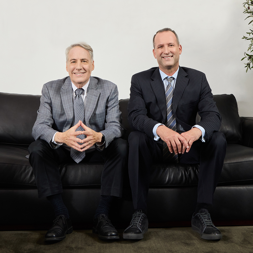 two men sitting on a couch