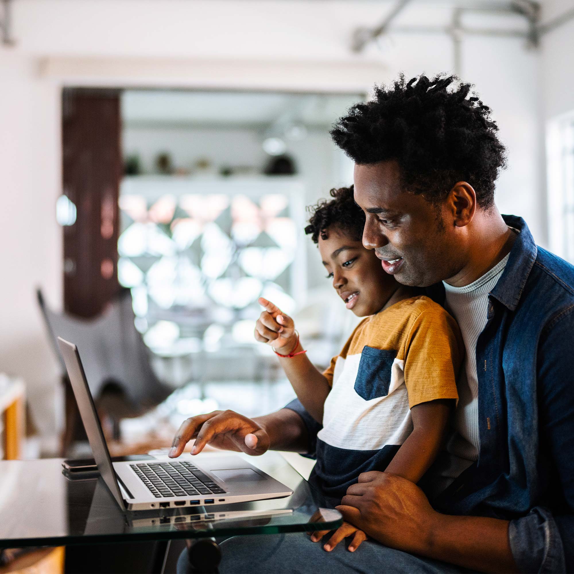 a man and child looking at a laptop