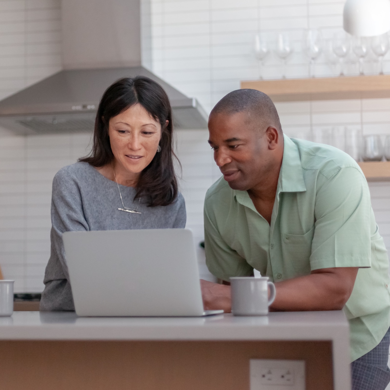 a man and woman looking at a laptop