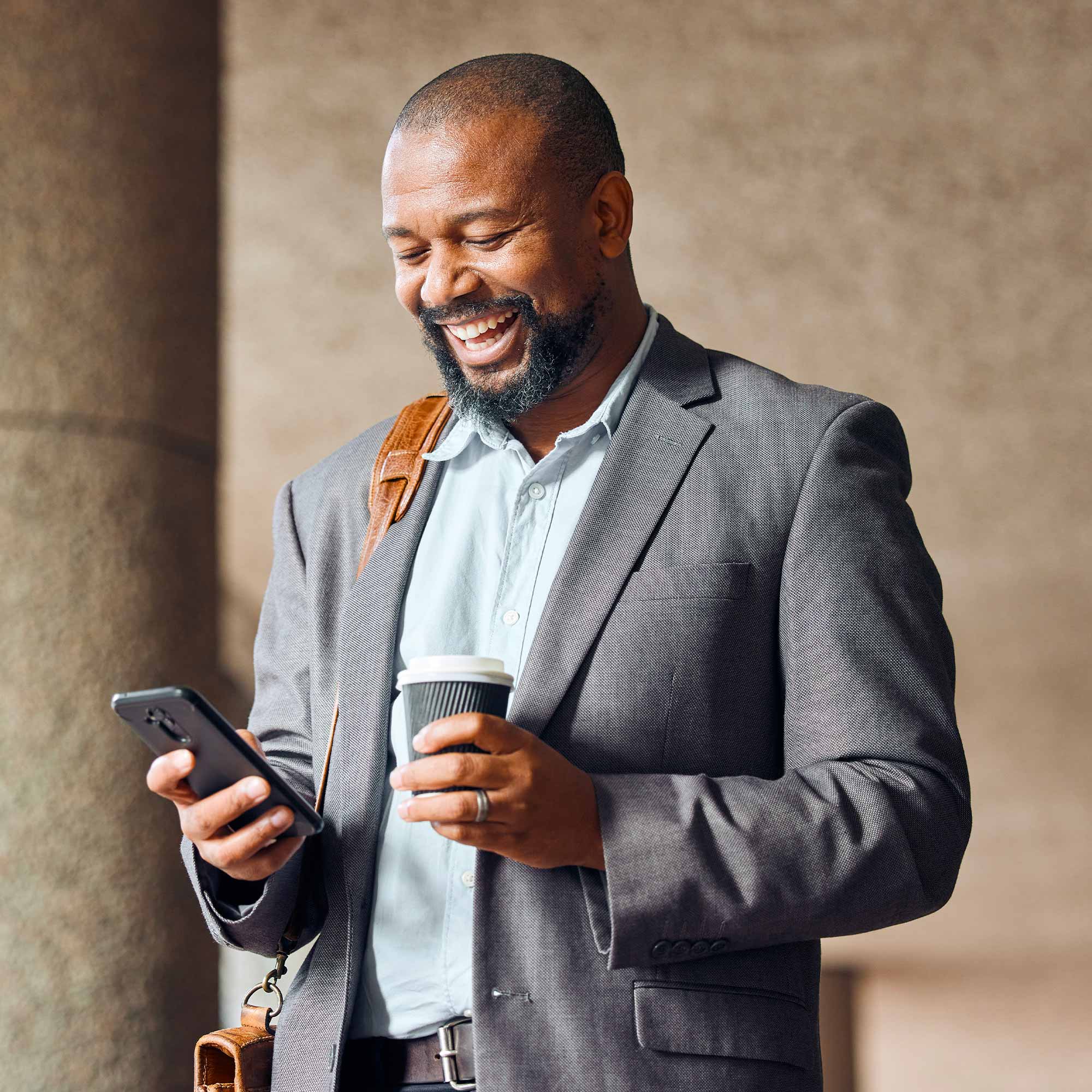 a man holding a cup and a phone