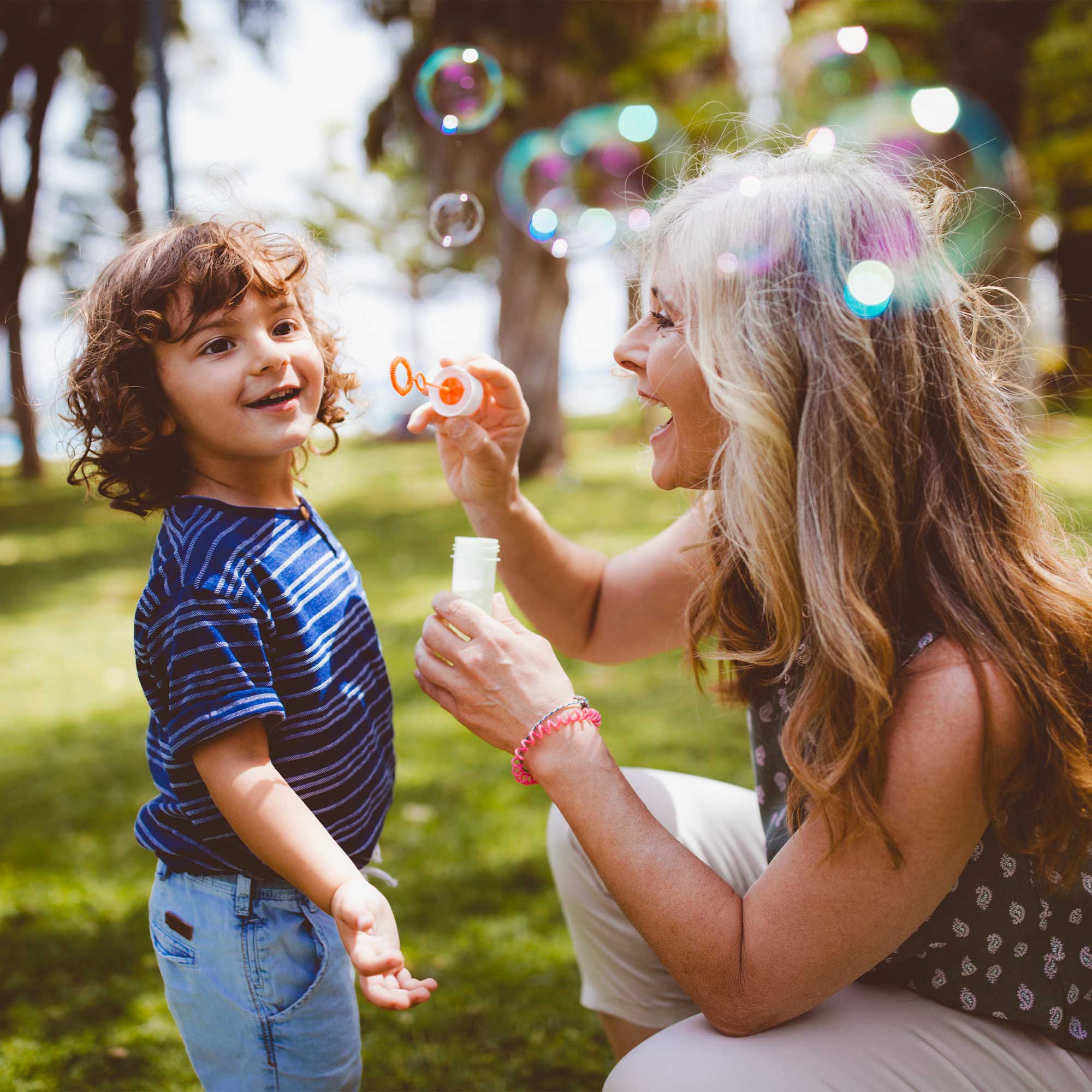 a woman and child blowing bubbles