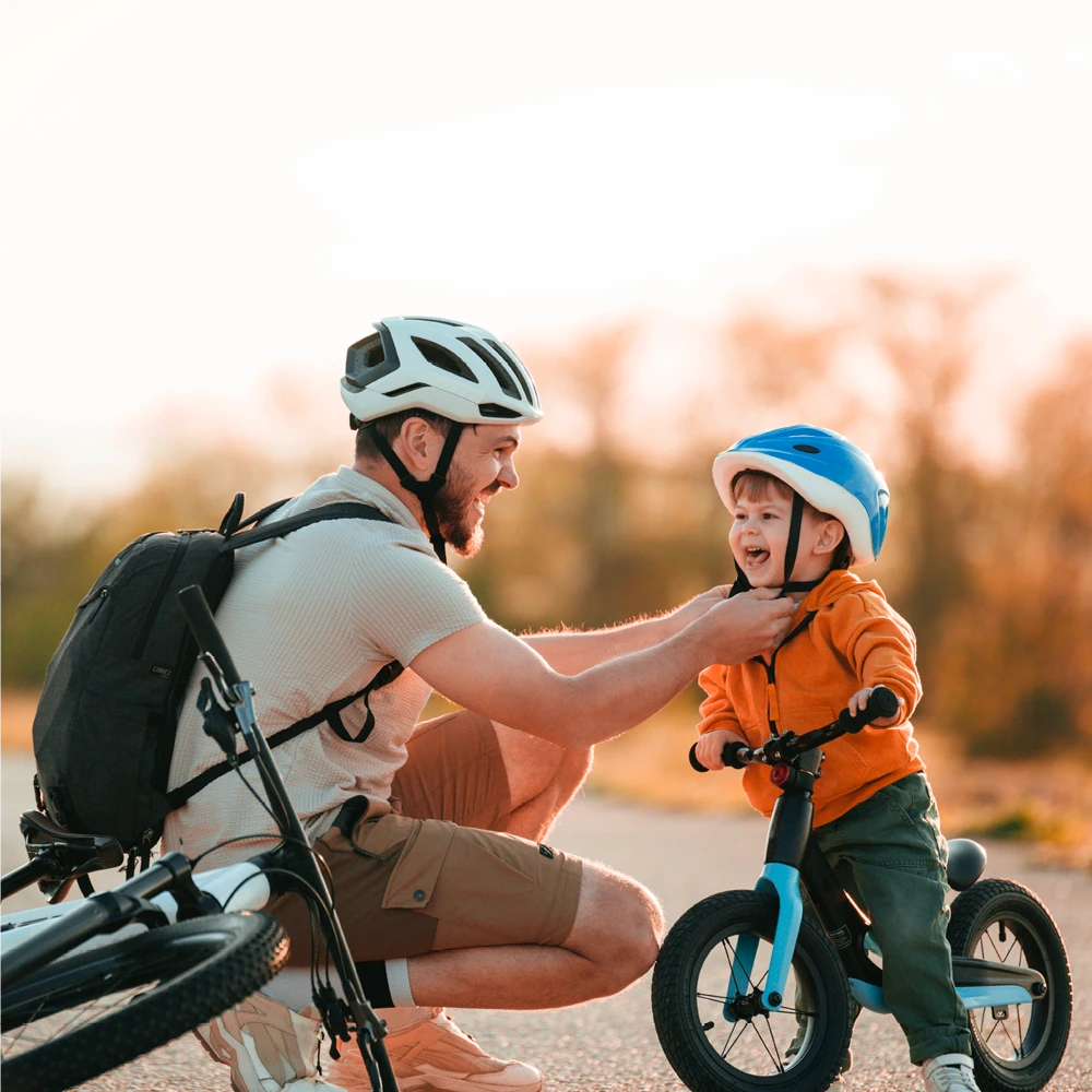 father helping his son ride a bike outdoors father helping his son ride a bike outdoors