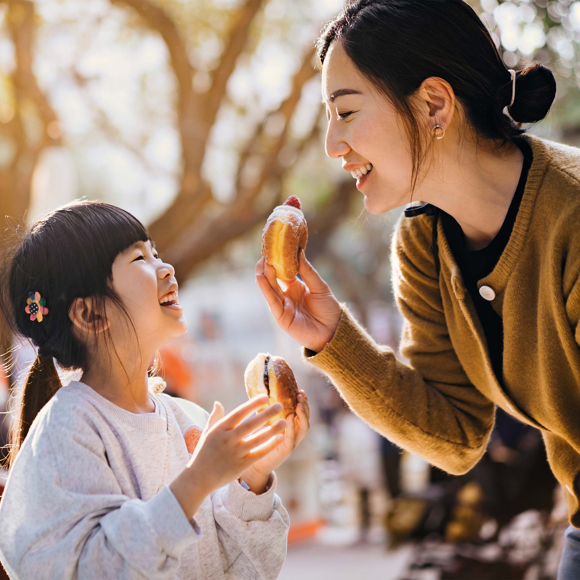 a woman and a child eating donuts