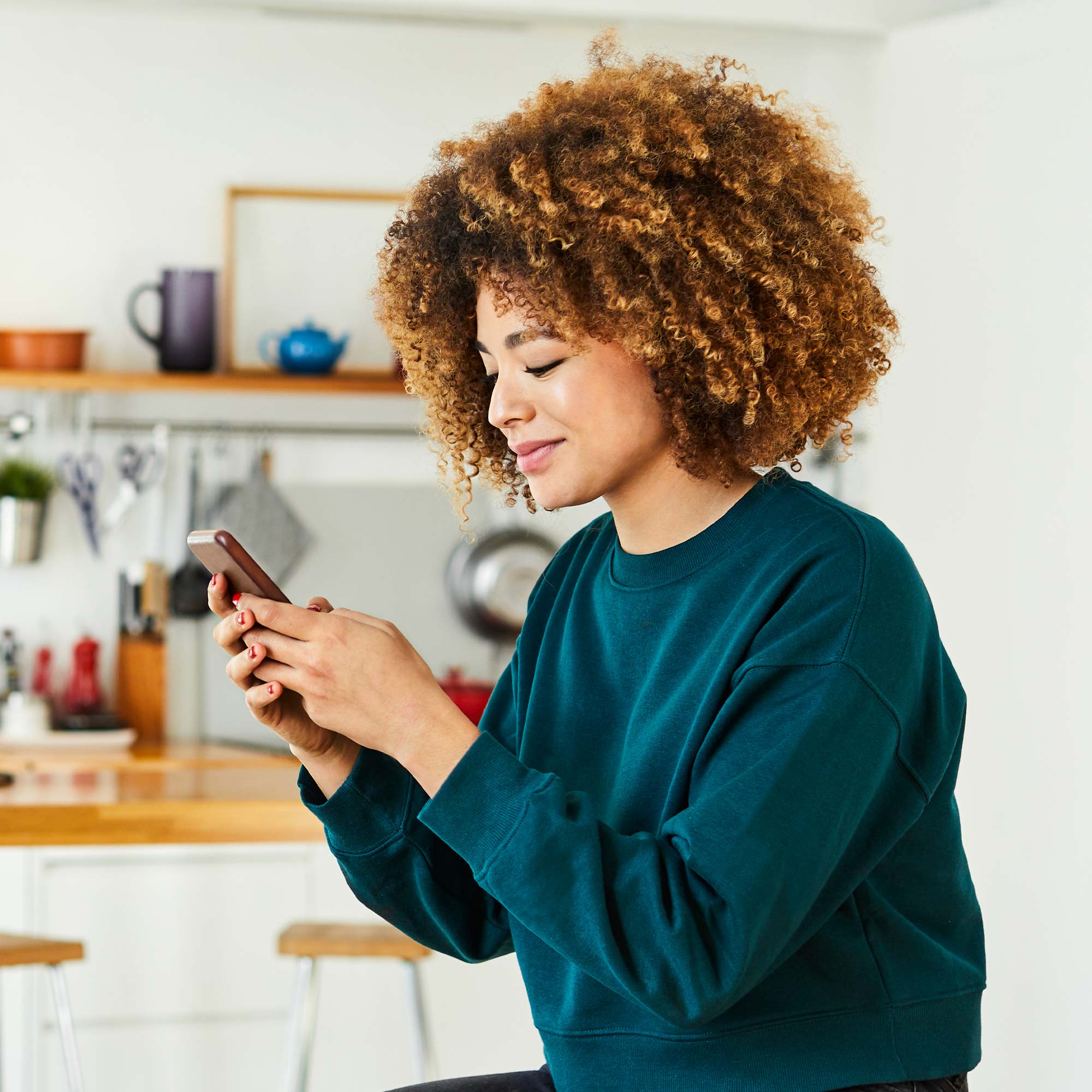 a woman with curly hair holding a phone