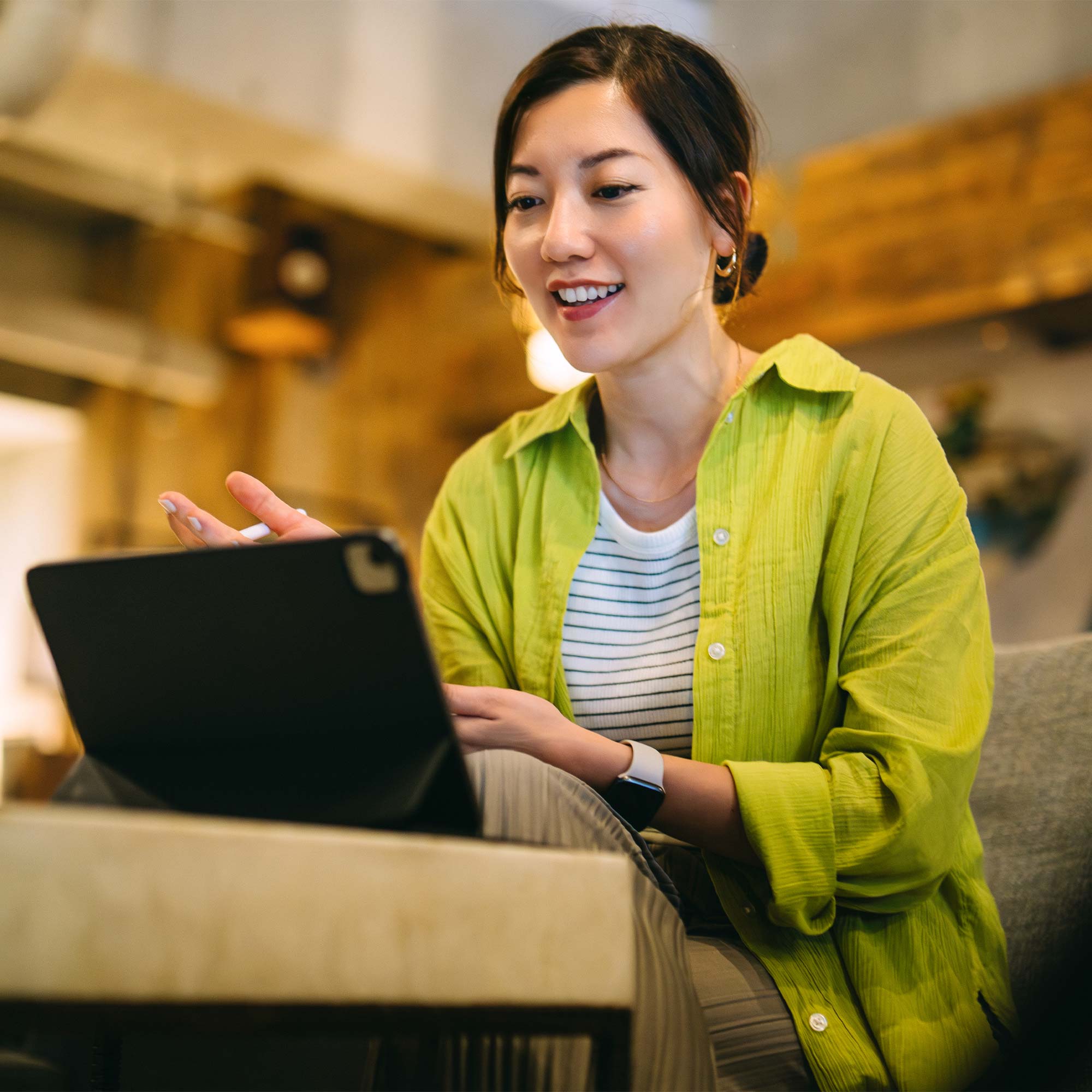 a woman sitting on a couch using a tablet