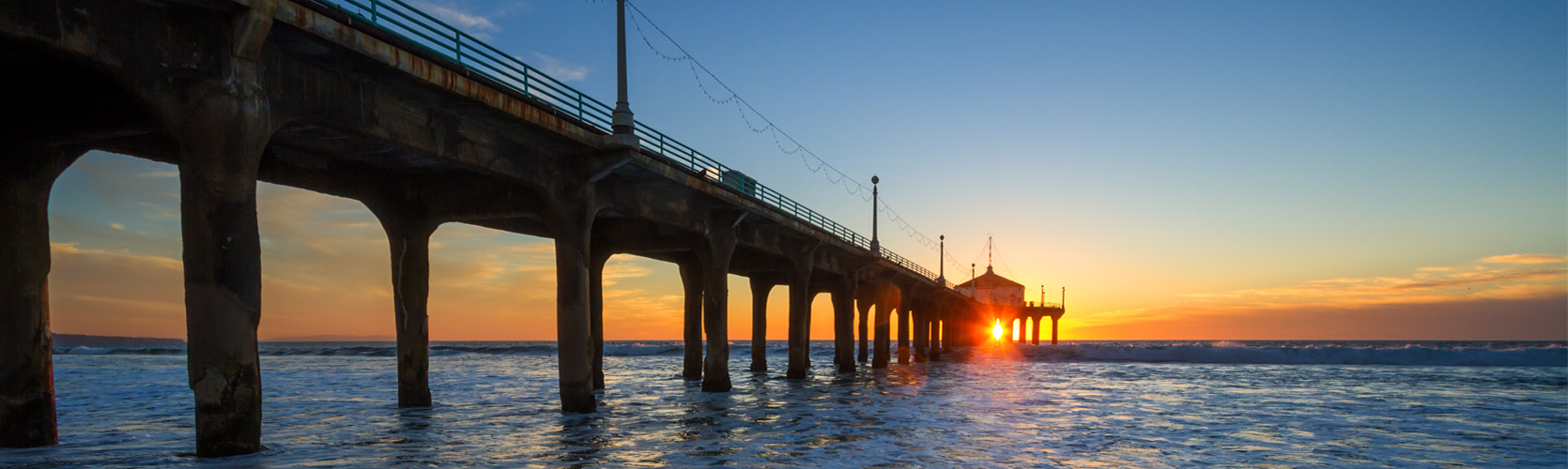 a long bridge over water with a building in the background