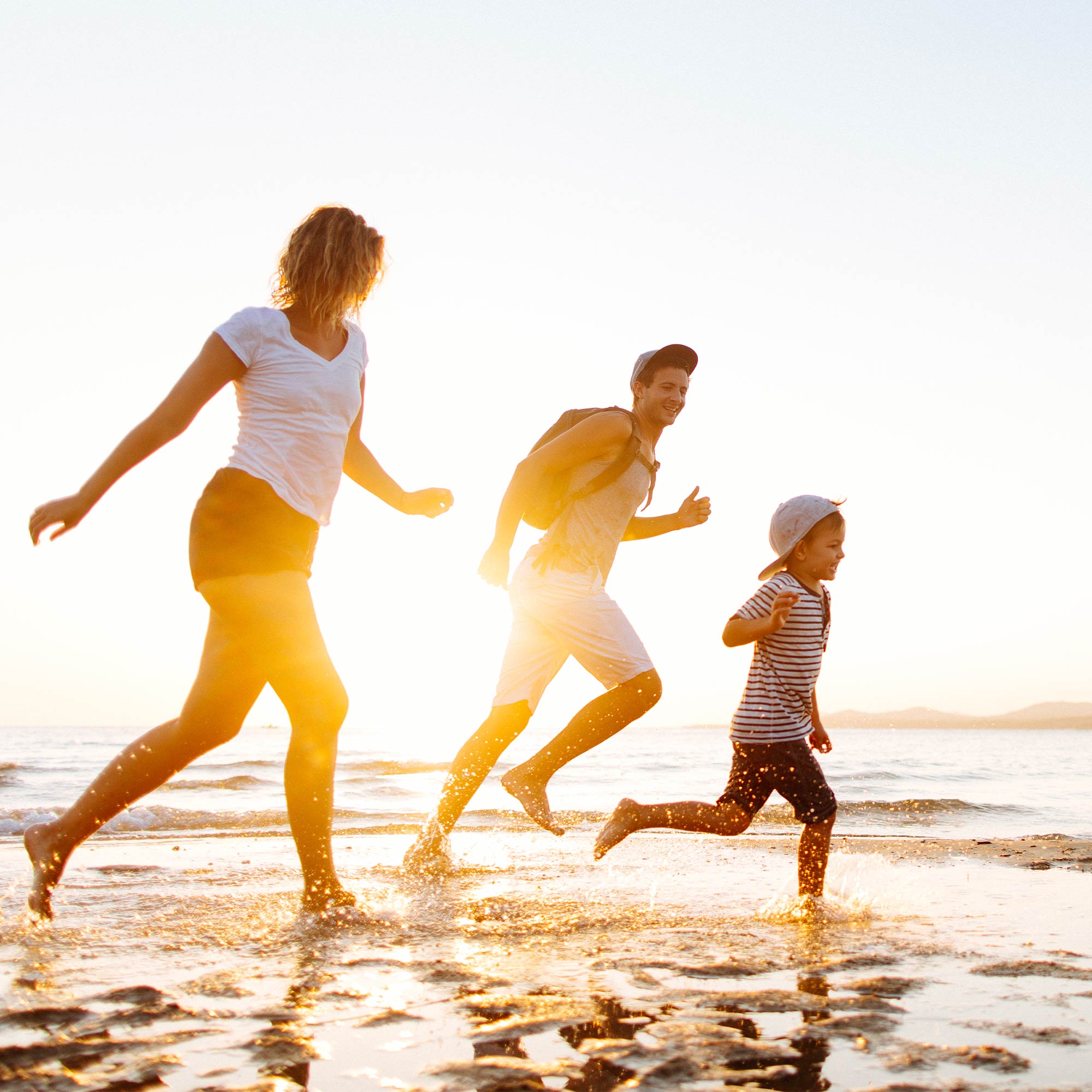 a group of people running on a beach