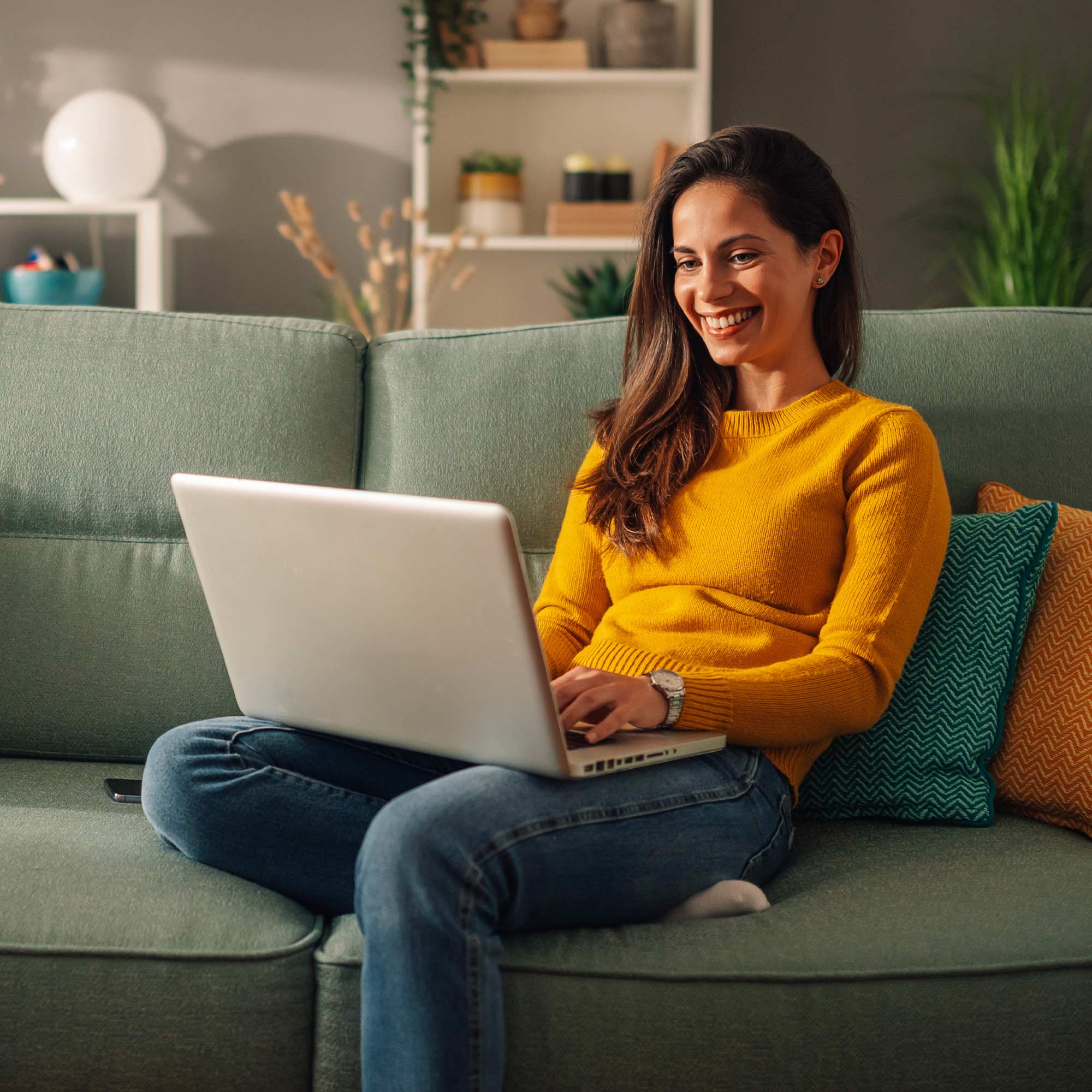 a woman sitting on a couch using a laptop