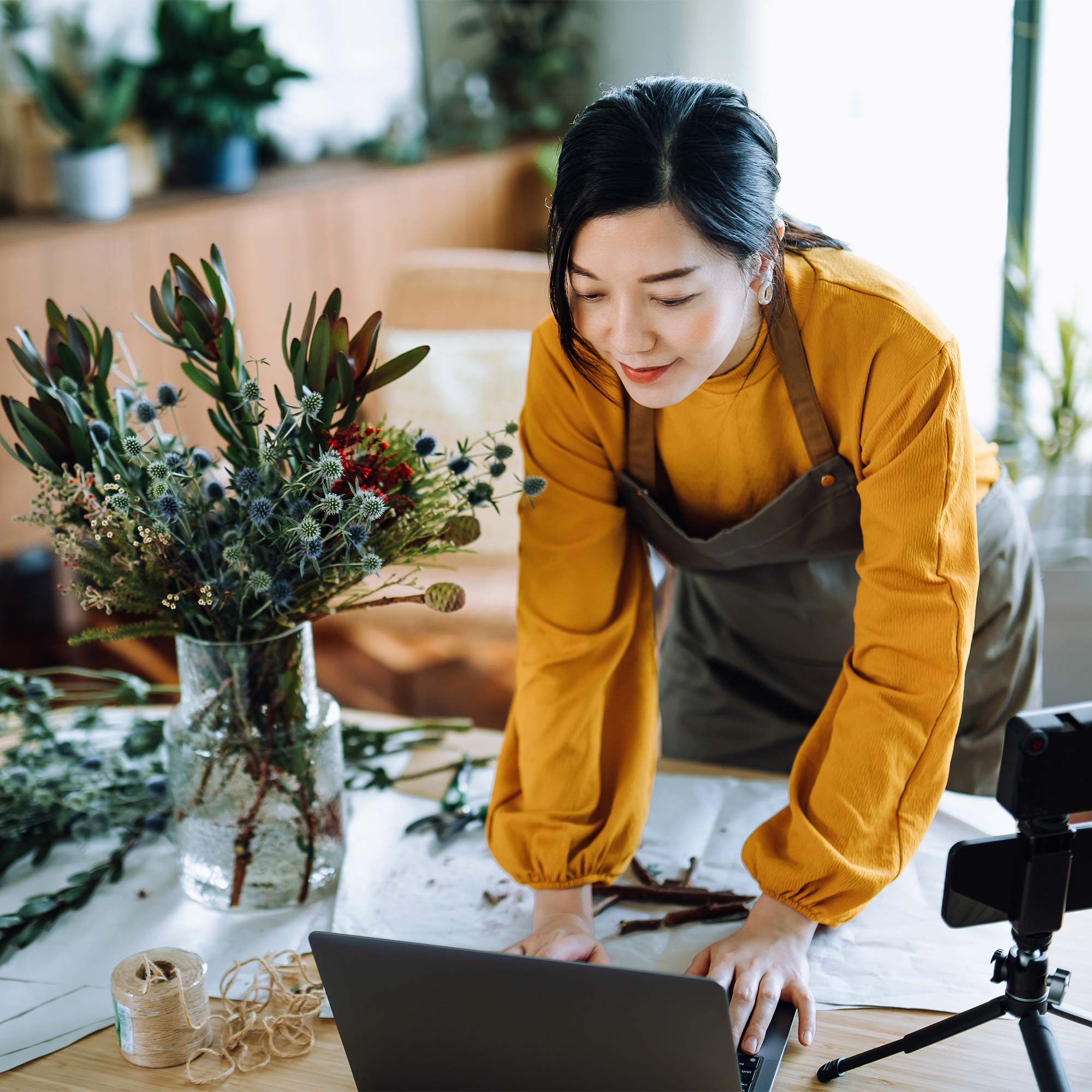 a woman in an apron working on a laptop