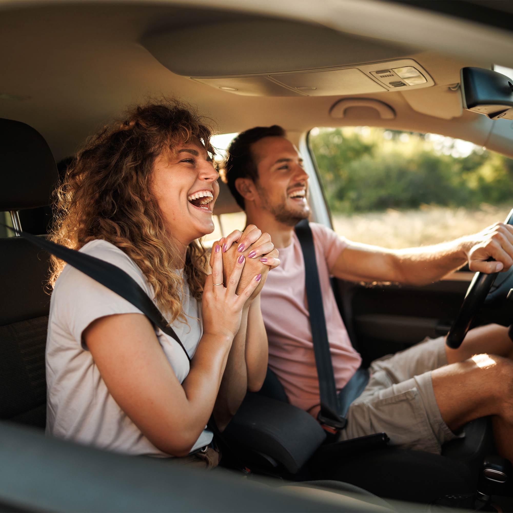 a man and woman laughing in a car