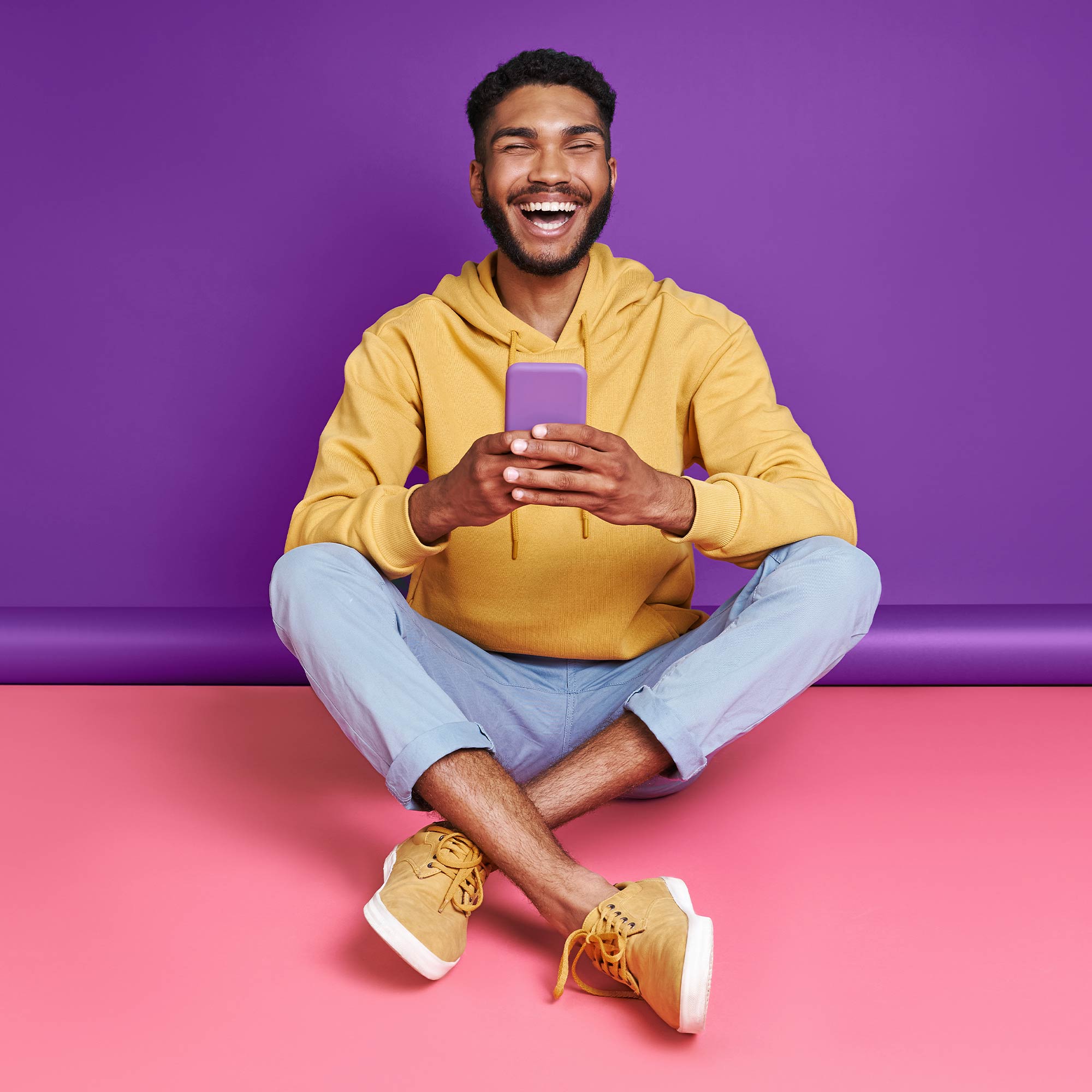 a man sitting cross legged with his legs crossed and smiling
