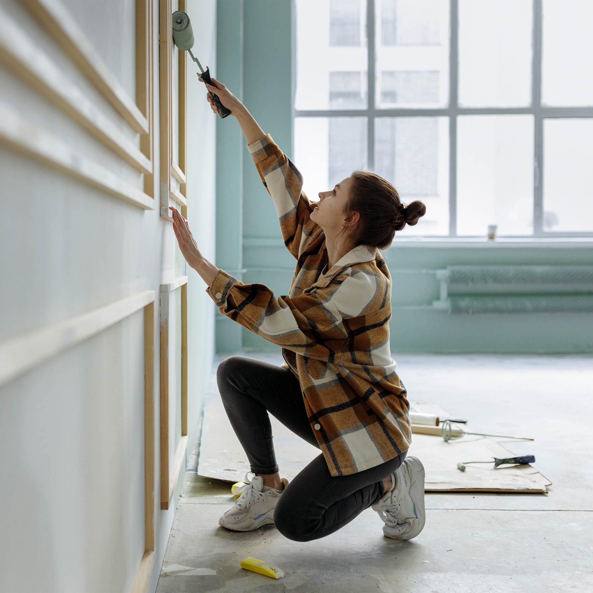 a woman painting a wall