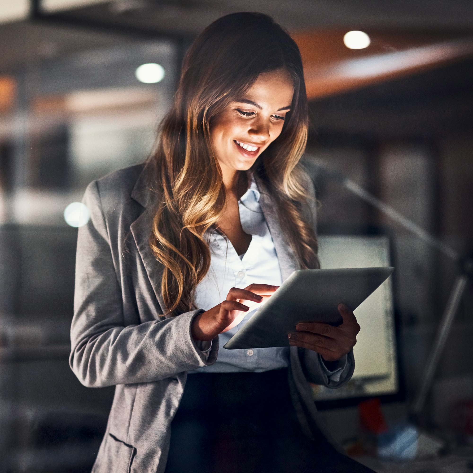 a woman in a suit using a tablet