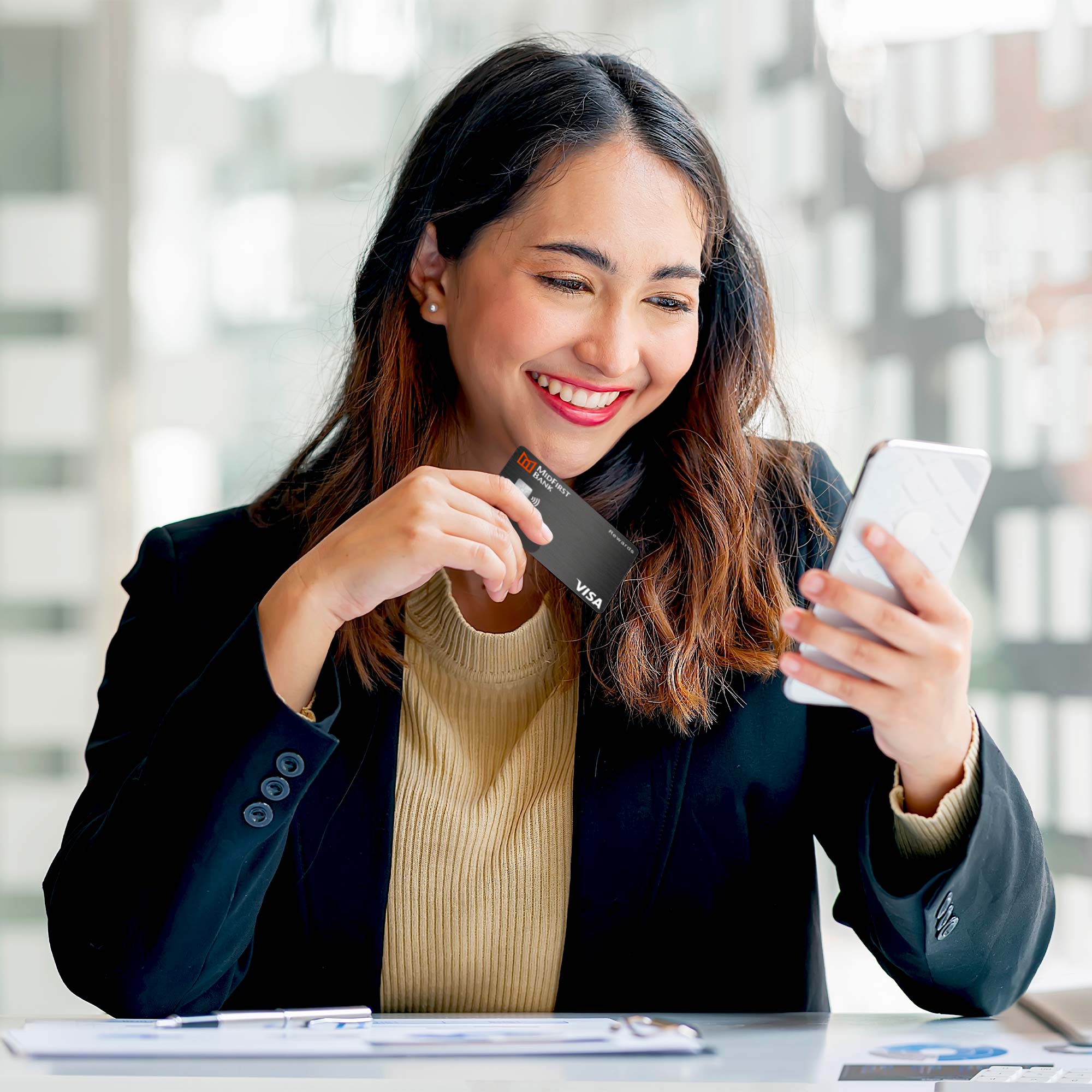 a woman holding a credit card and a phone