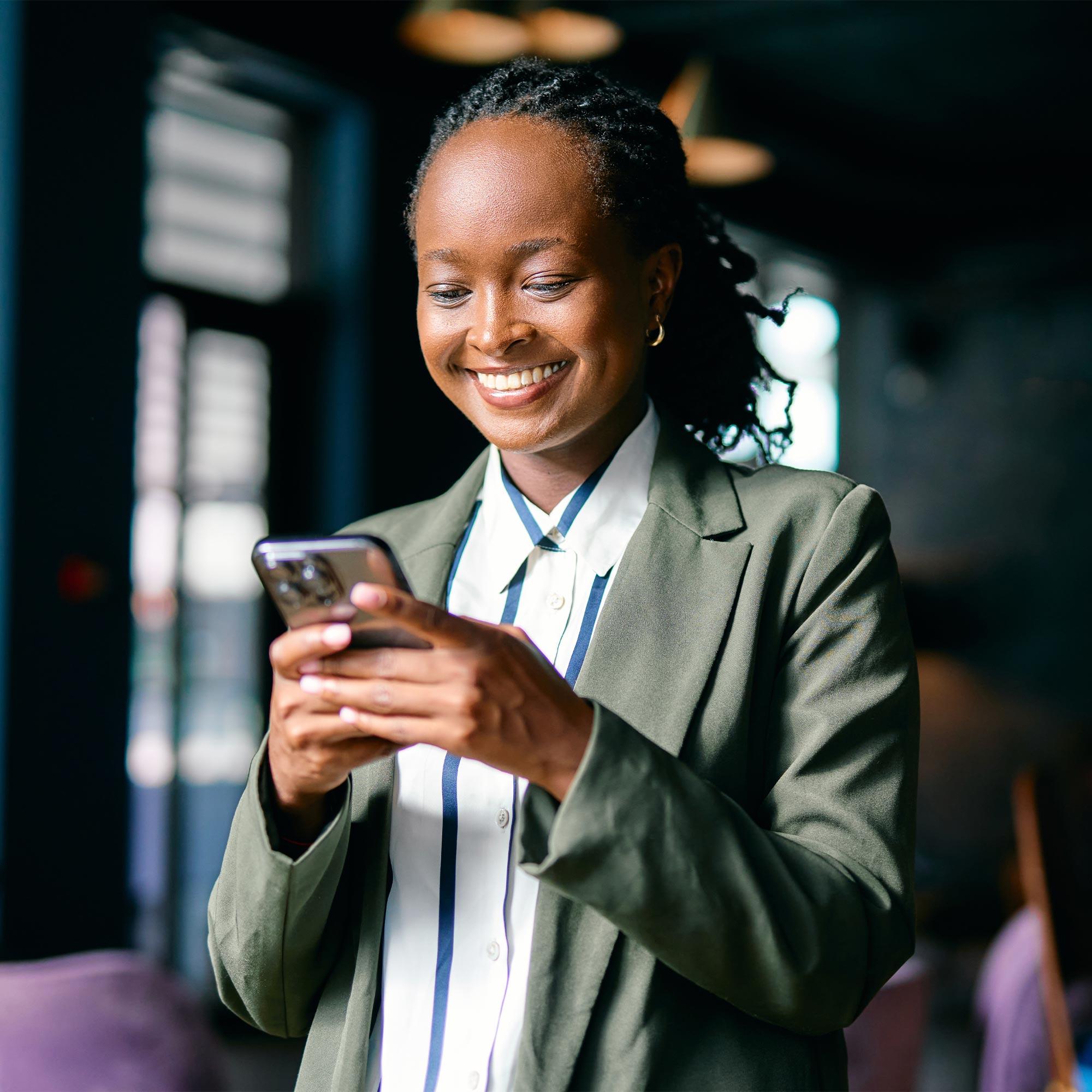 a woman smiling while holding a phone