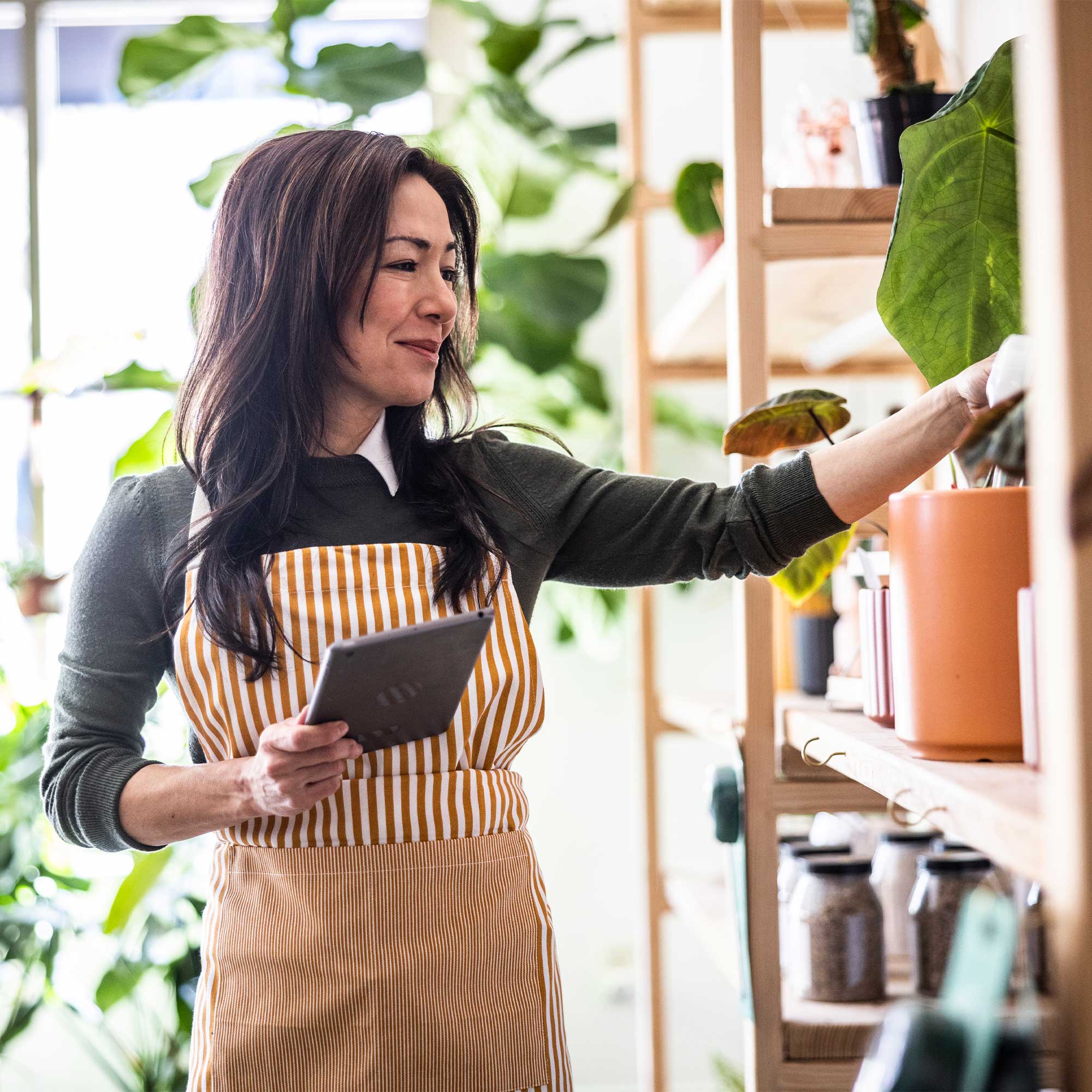 a woman in an apron holding a tablet