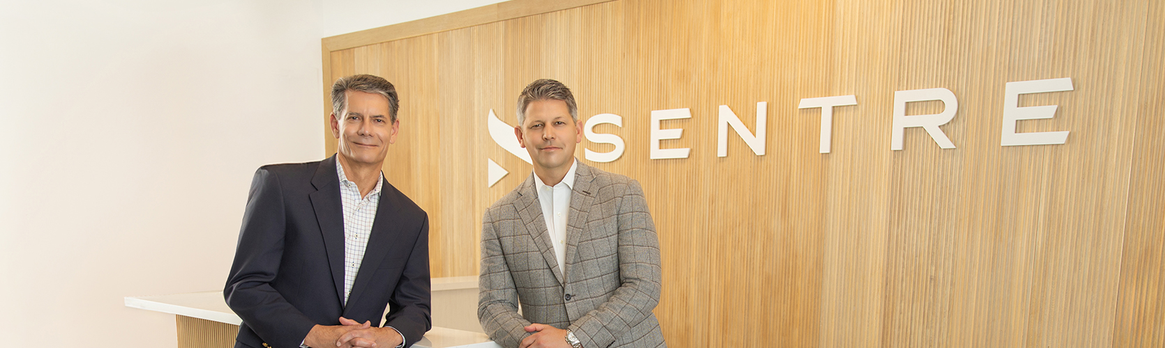 a man in a suit standing next to a man in a suit