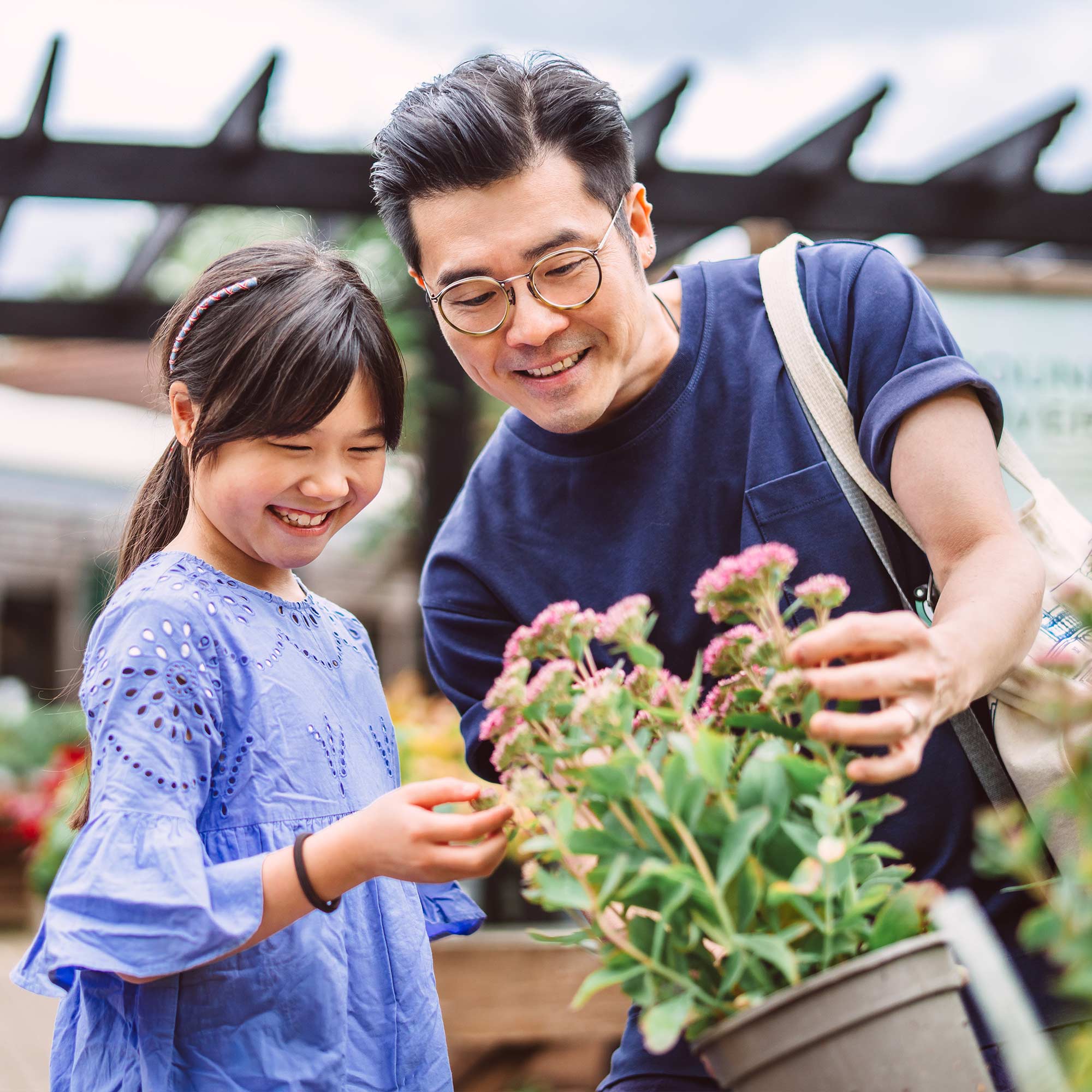 a man and girl looking at a plant