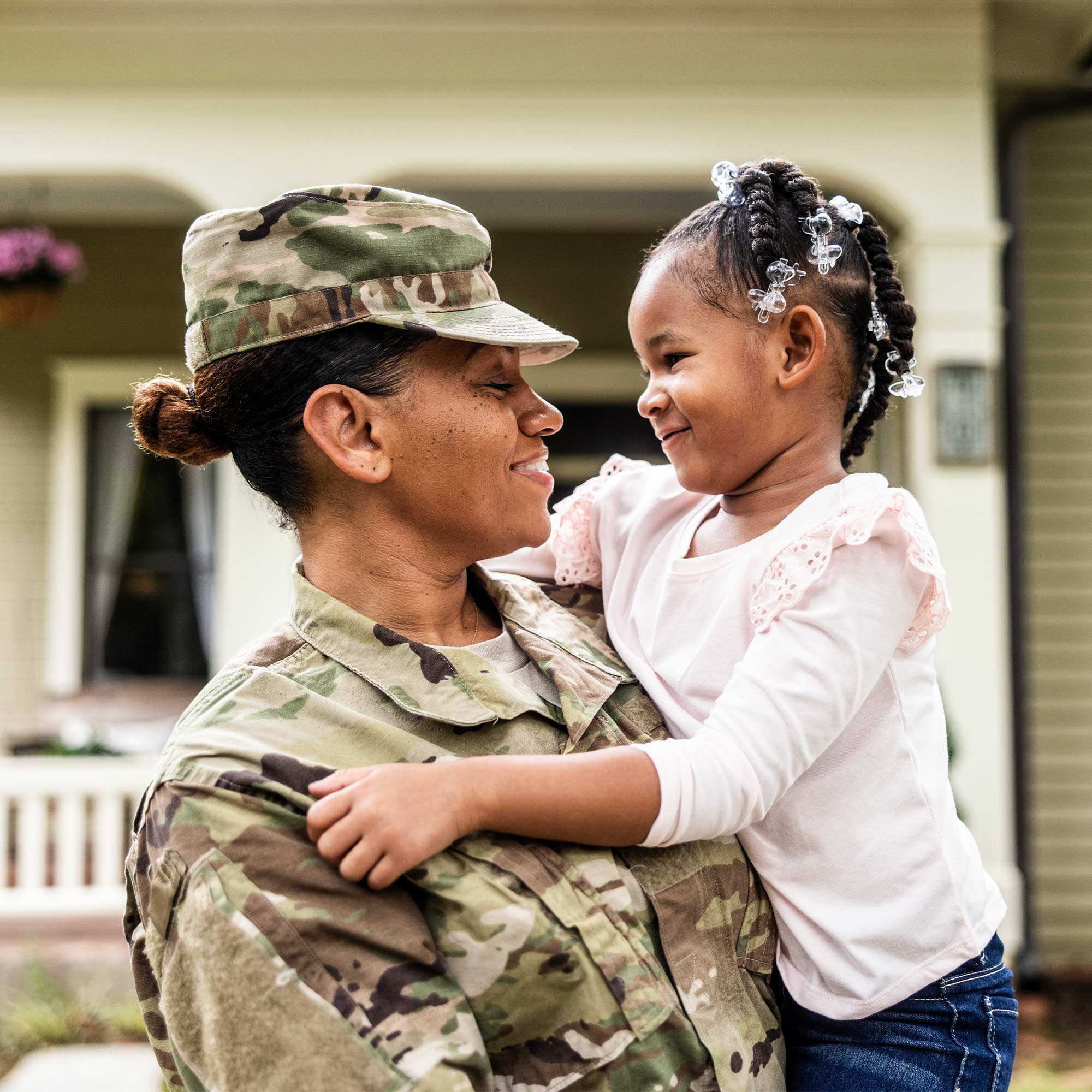 a woman in military uniform holding a child