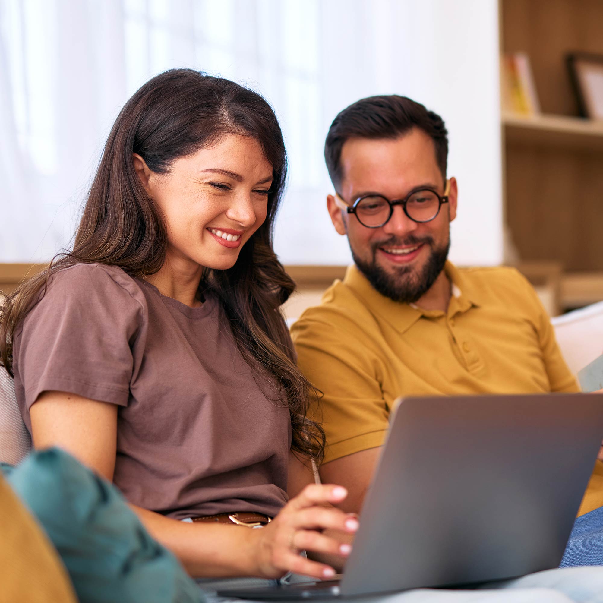 a man and woman looking at a laptop