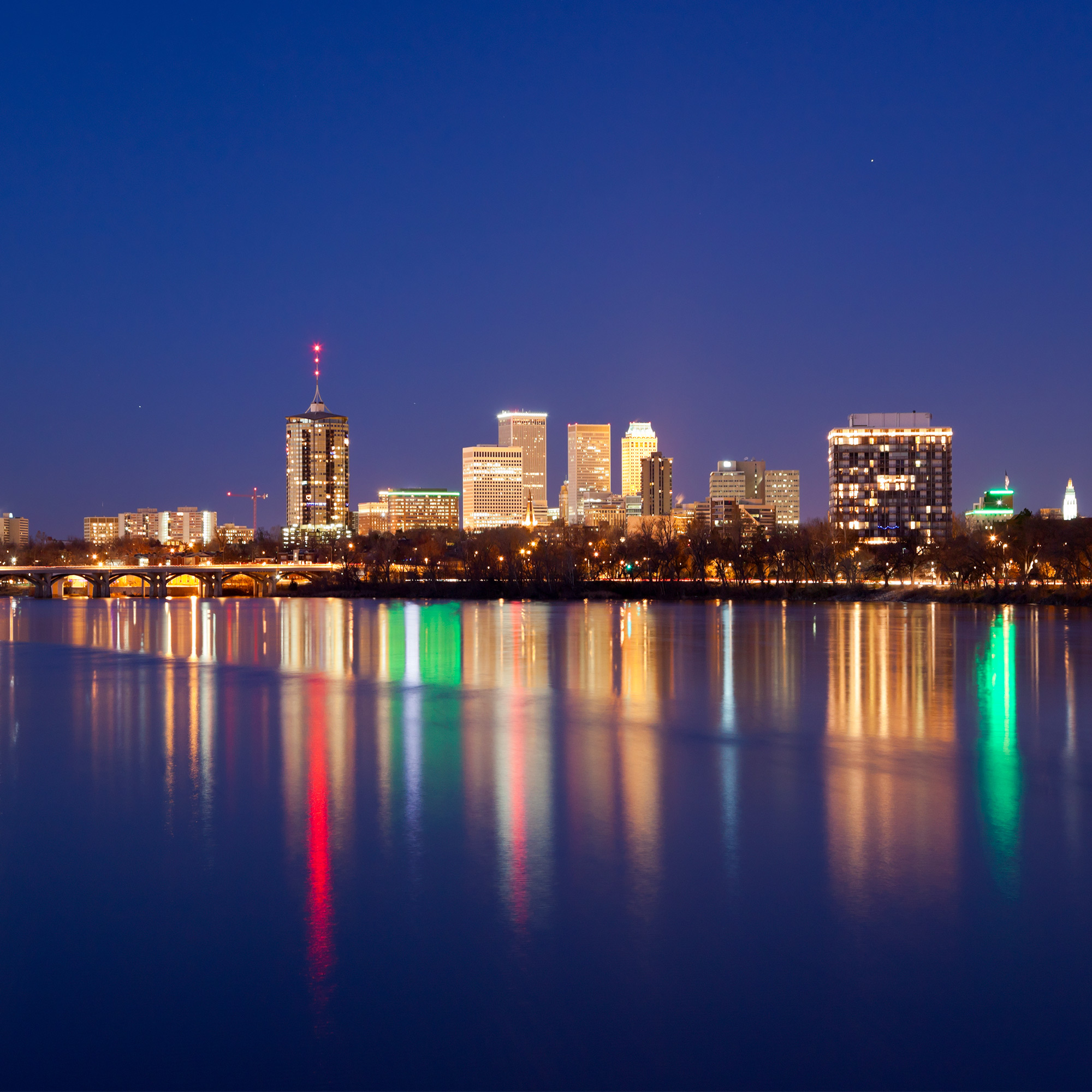 a city skyline with lights reflecting on water