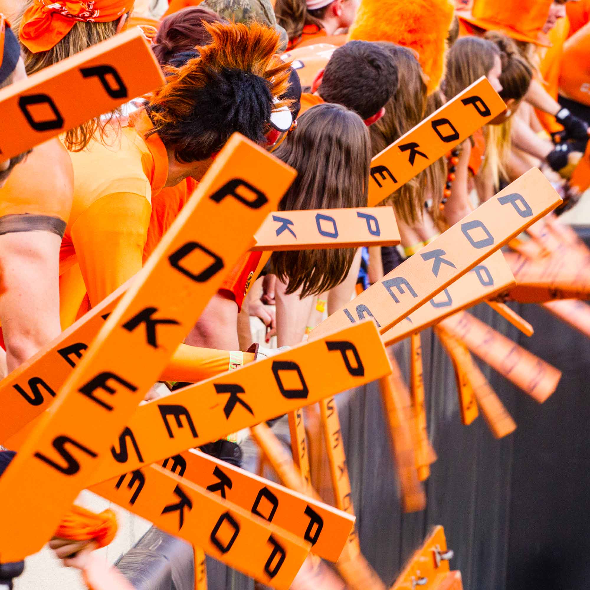 a group of people in orange shirts holding signs