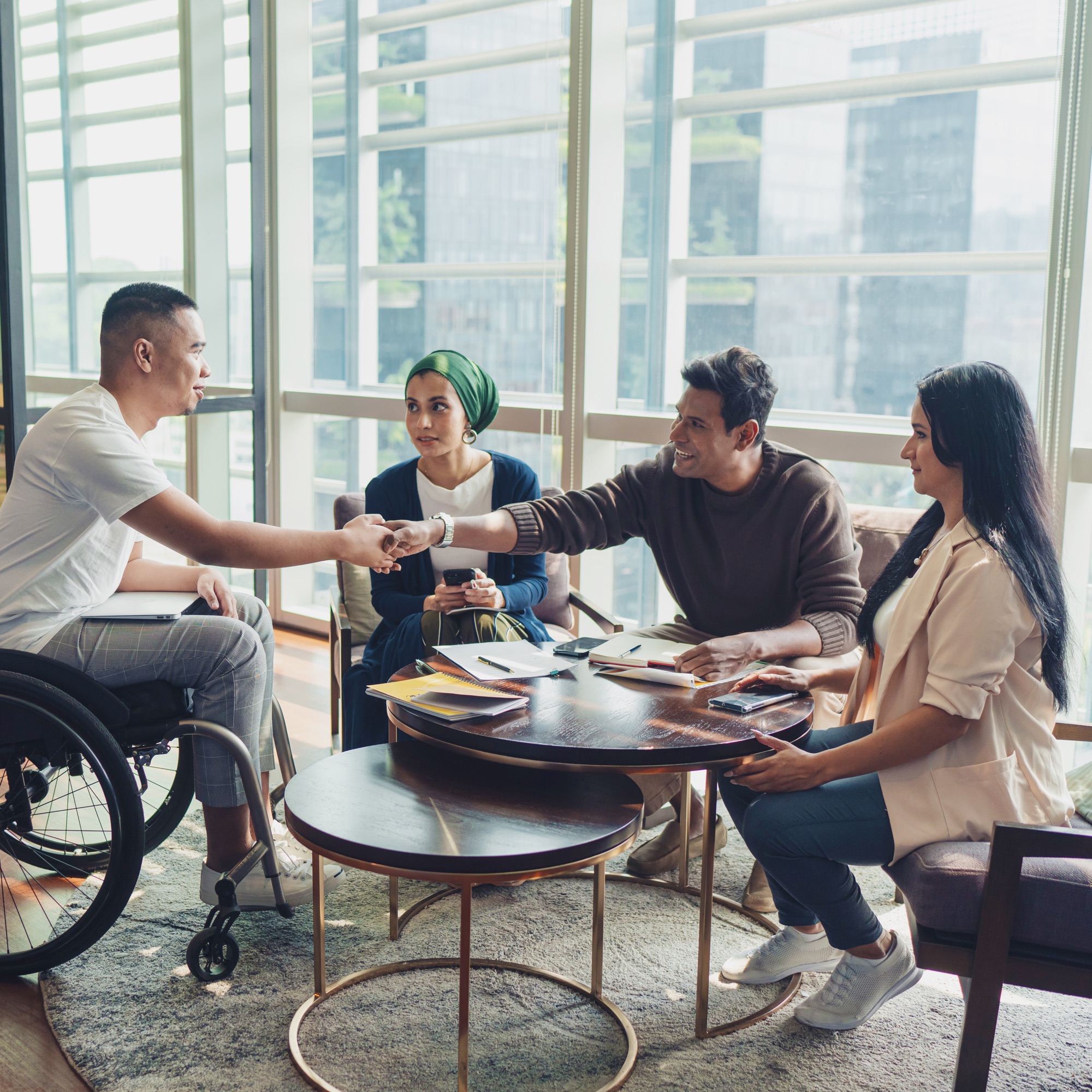 a man shaking hands with a group of people around a table