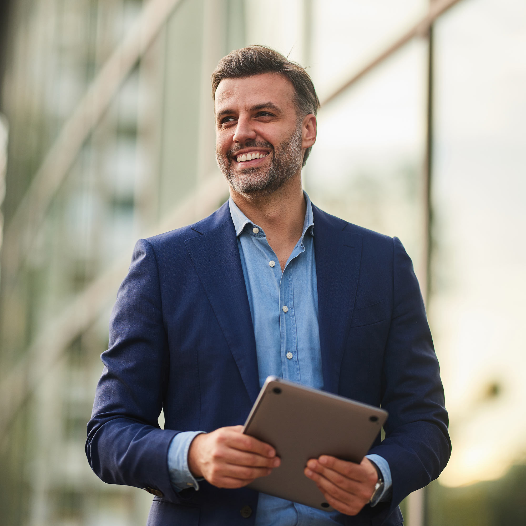 a man in a suit holding a tablet
