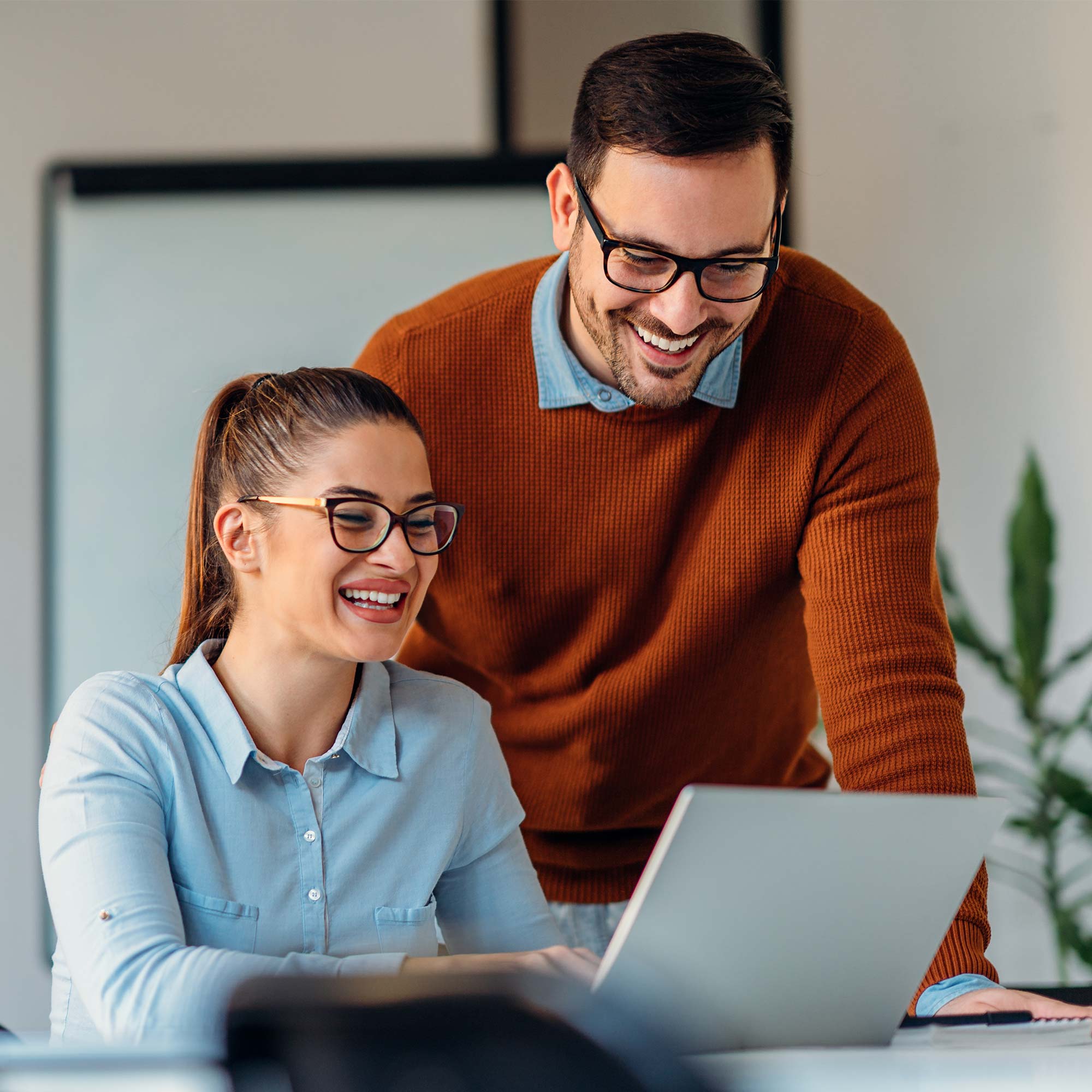 a man and woman looking at a laptop