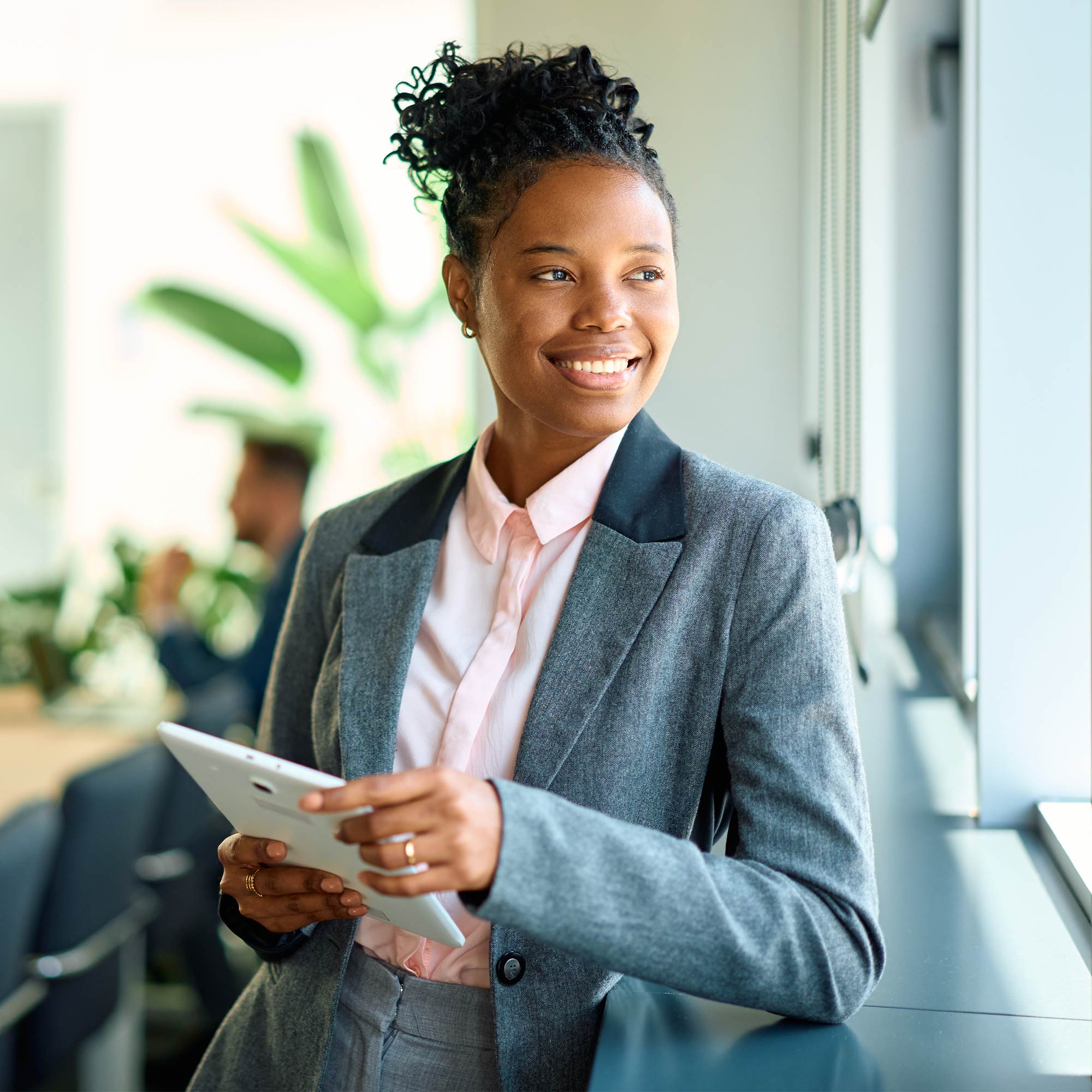a woman in a suit holding a tablet