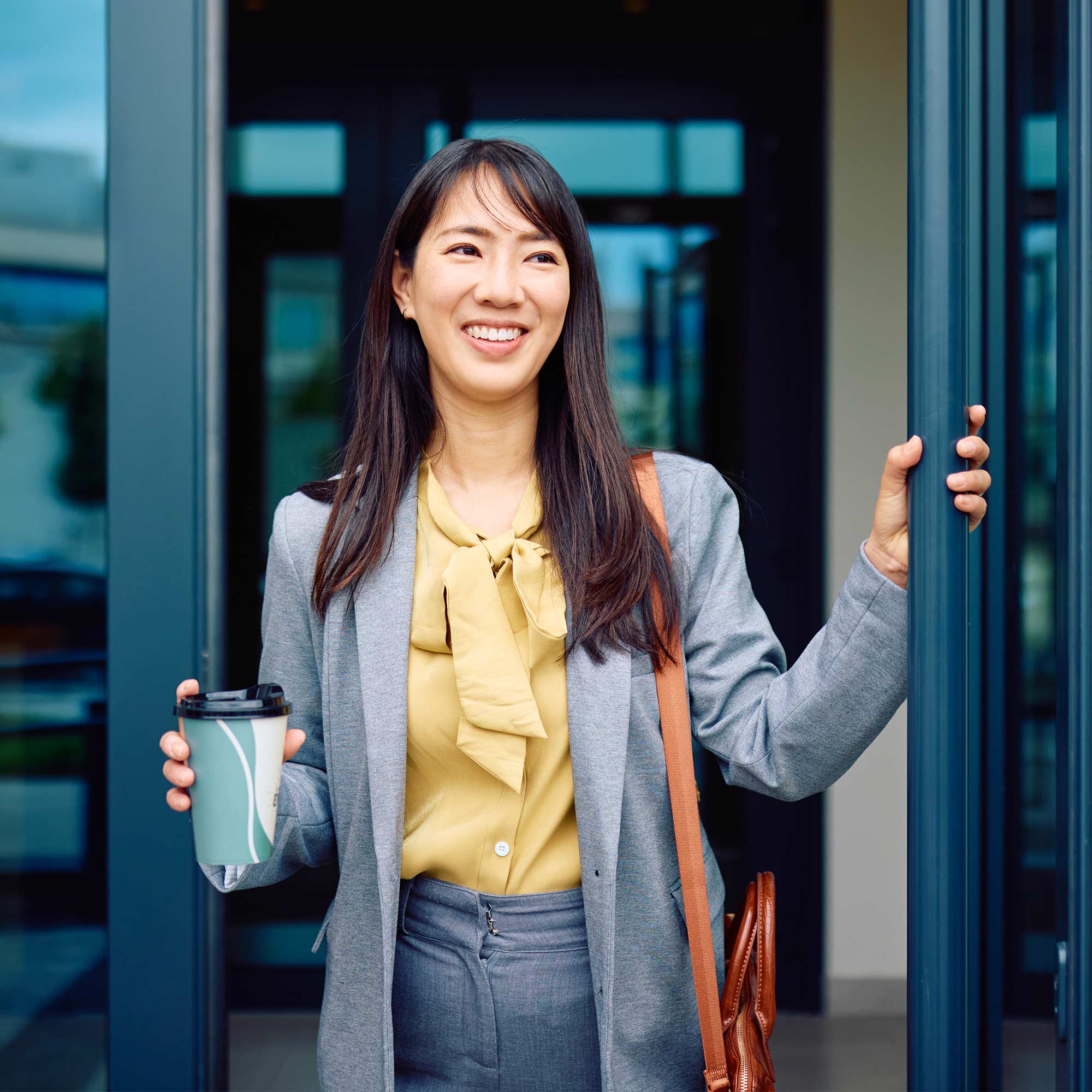 a woman holding a coffee cup and smiling