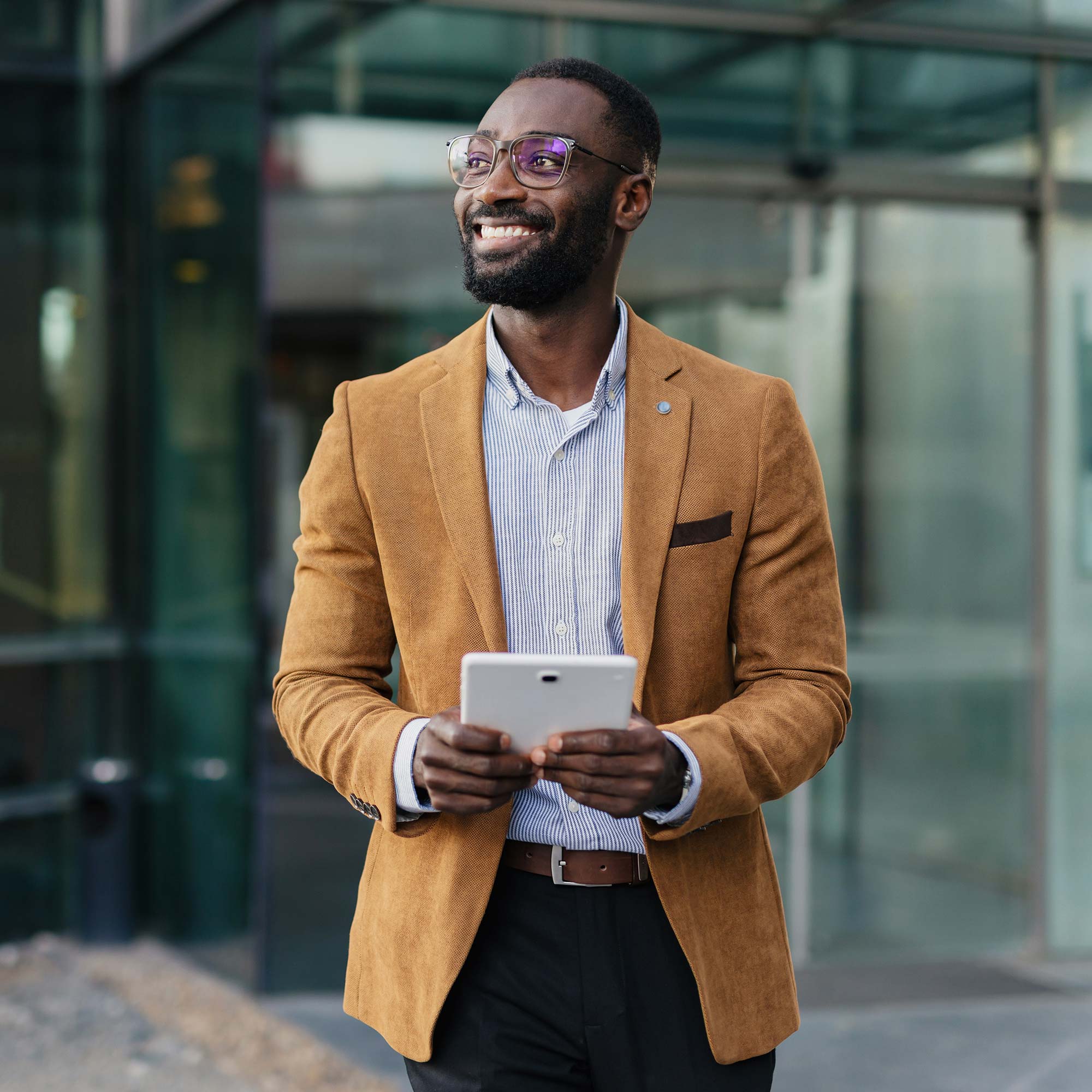 a man in a brown jacket holding a tablet