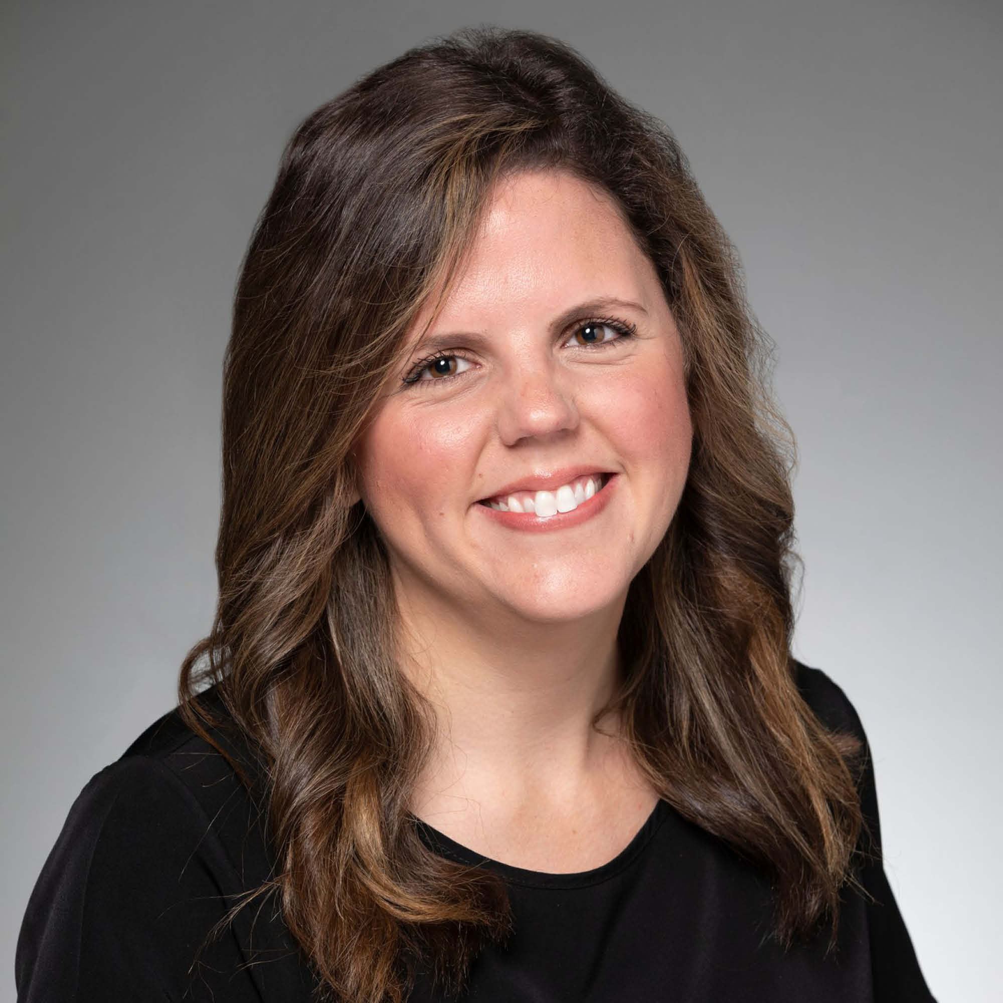 a woman with brown hair wearing a black shirt