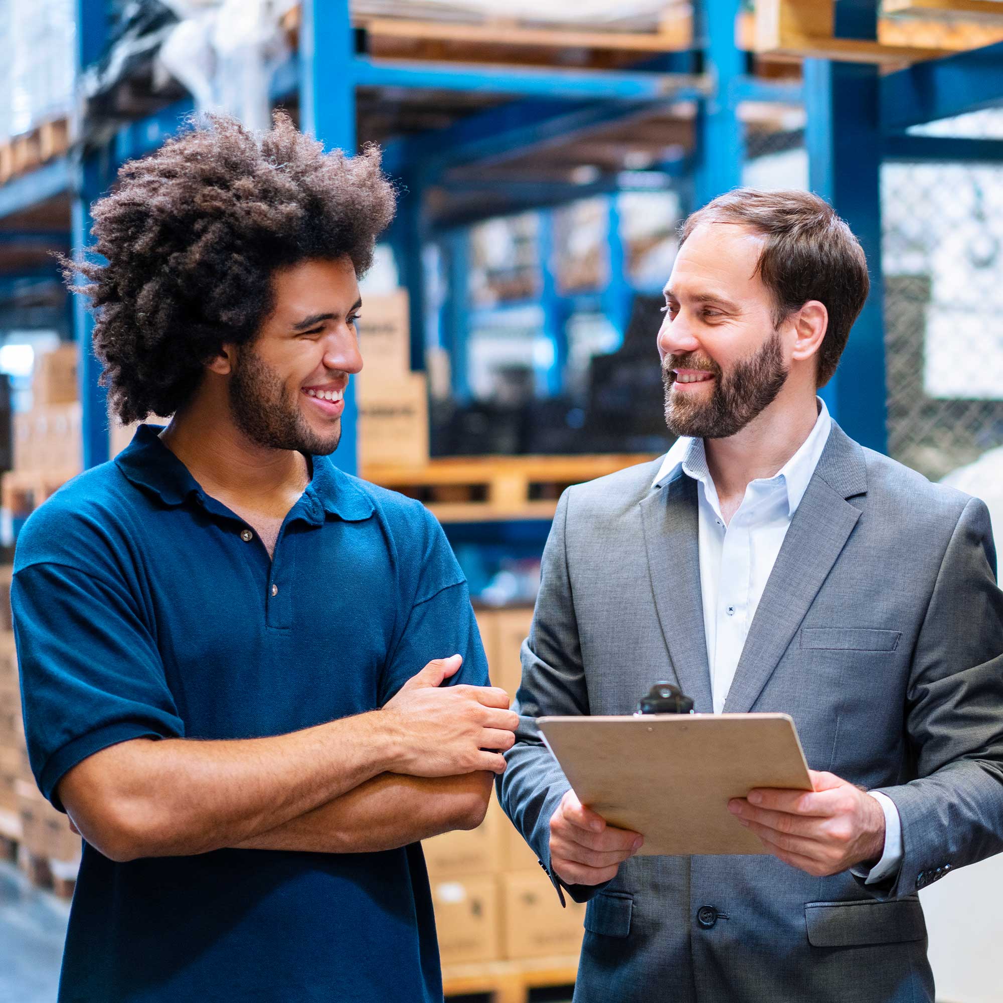 a man holding a clipboard and smiling at another man