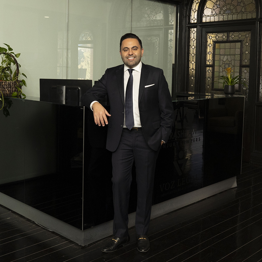a man in a suit leaning on a black counter