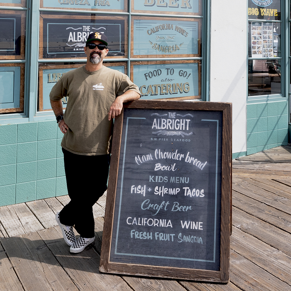 a man standing next to a sign