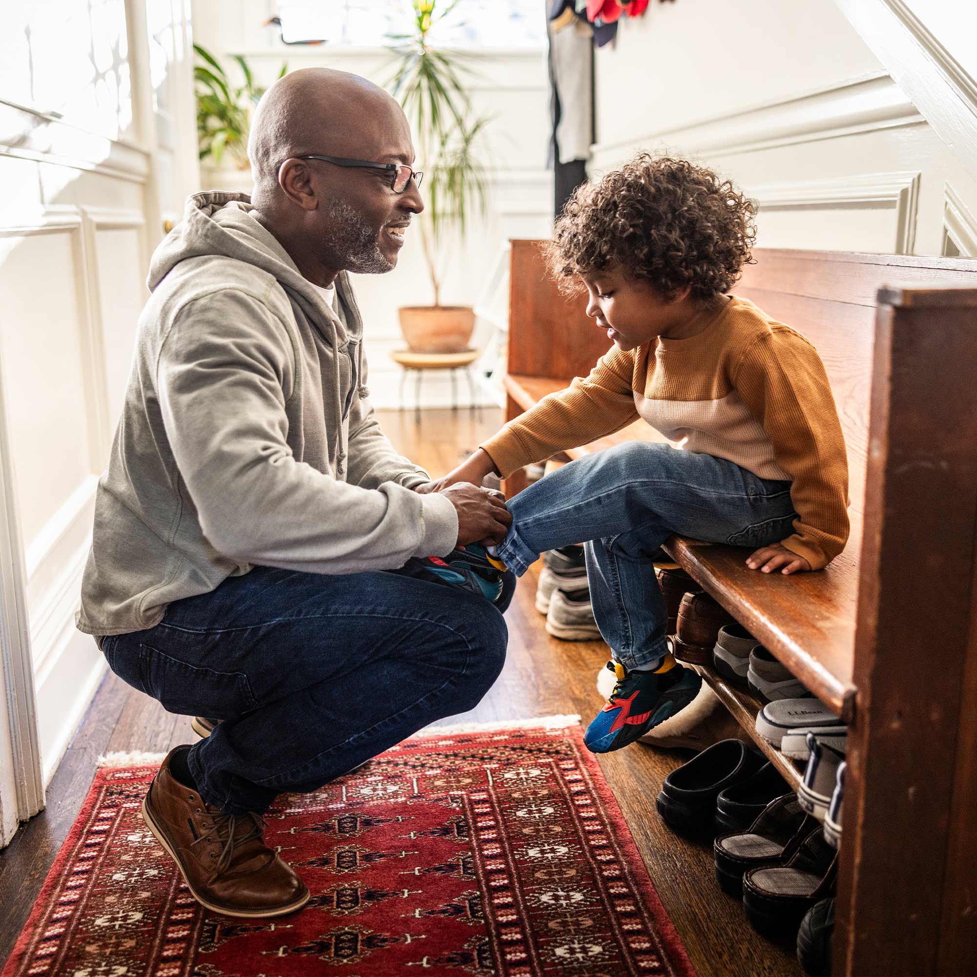 a man kneeling on a bench with a child on it