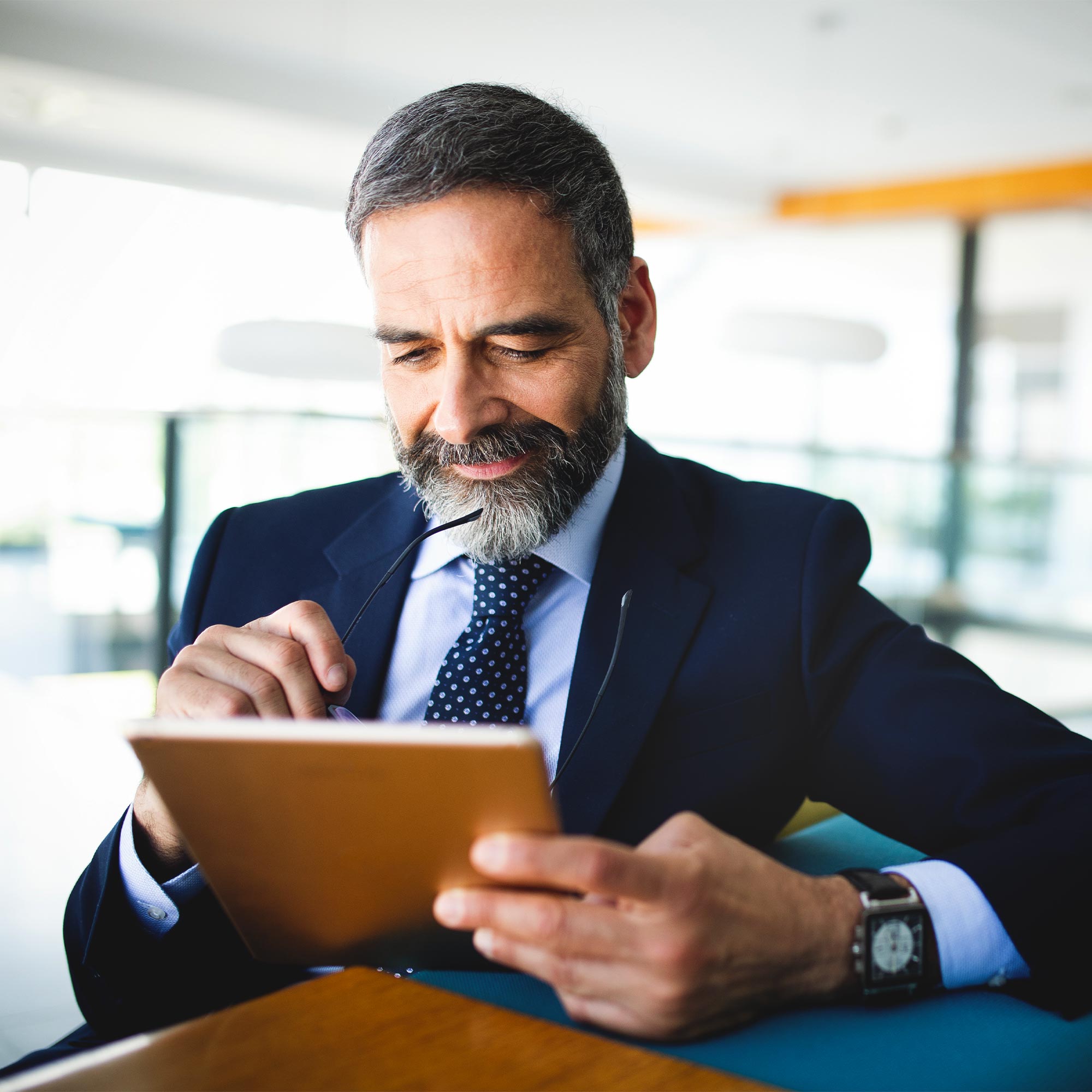 a man in a suit and tie looking at a tablet