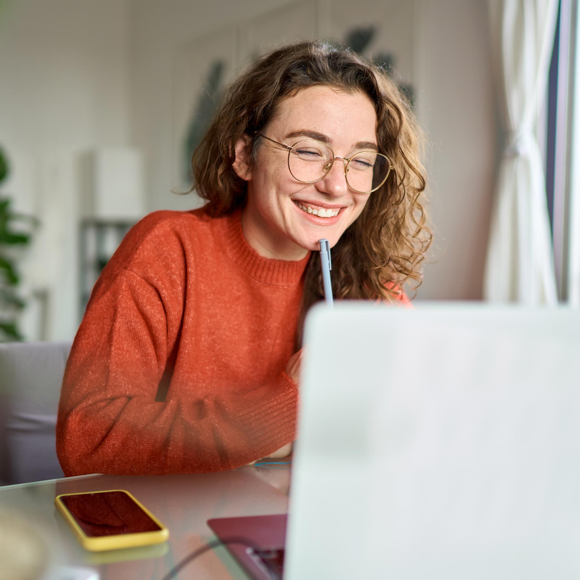a woman smiling at a laptop