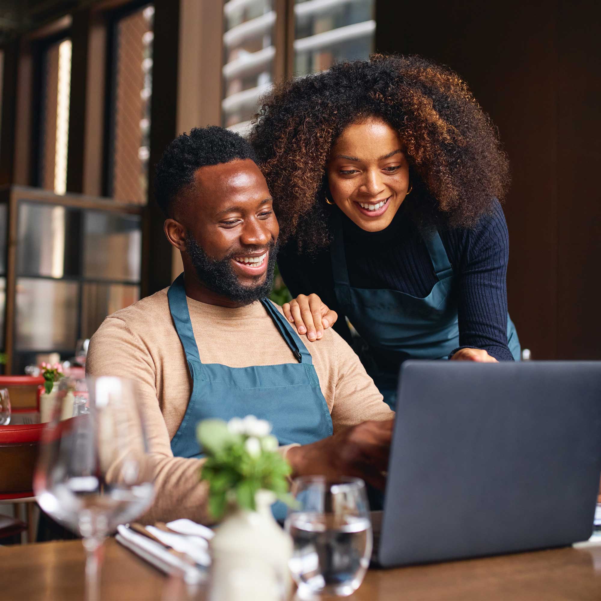 a man and woman looking at a laptop